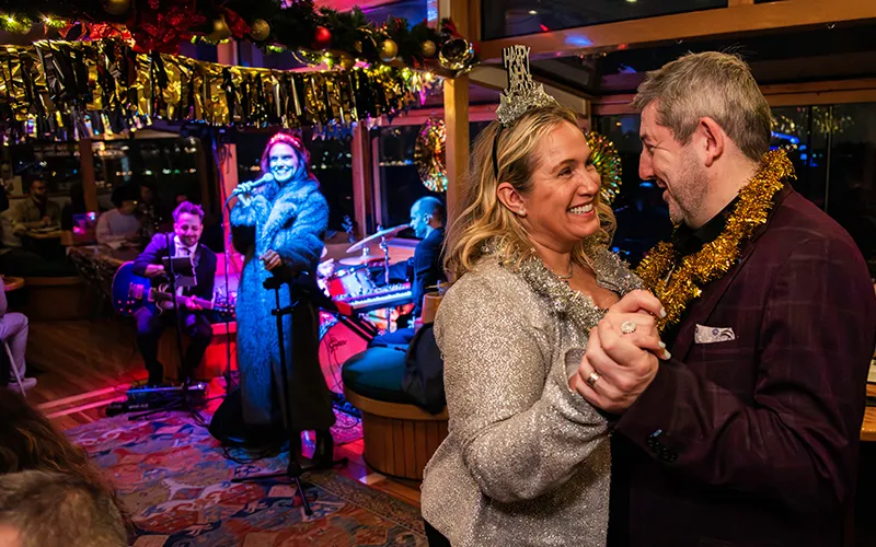 NewYear13 Couple dancing on New Year's Eve on a yacht with a band in the background and decorations all around