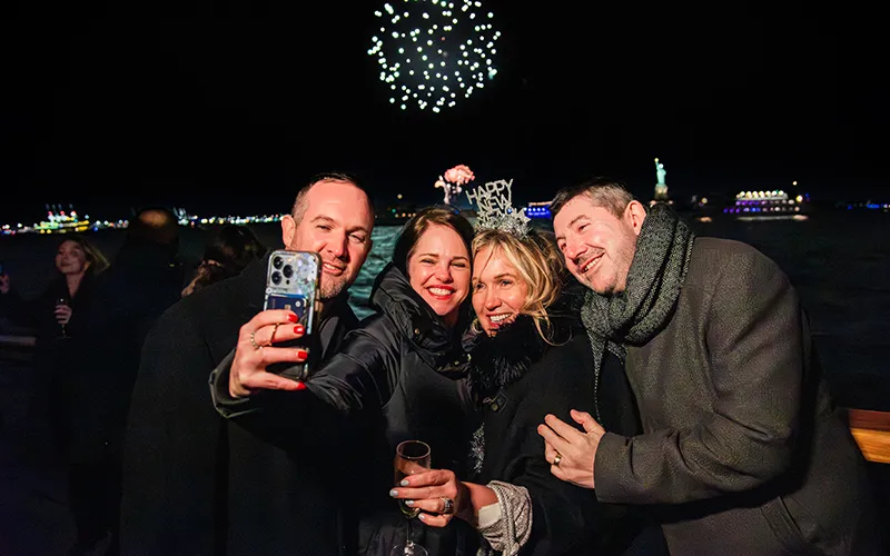 NewYear17 Group of friends taking a selfie with the Statue of Liberty and Fireworks in the background