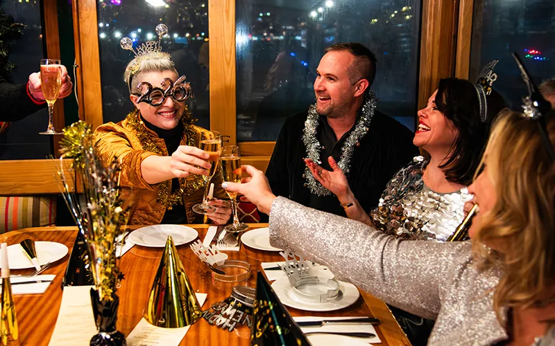 NewYear4 Two women and a couple cheering champagne at a table on a yacht