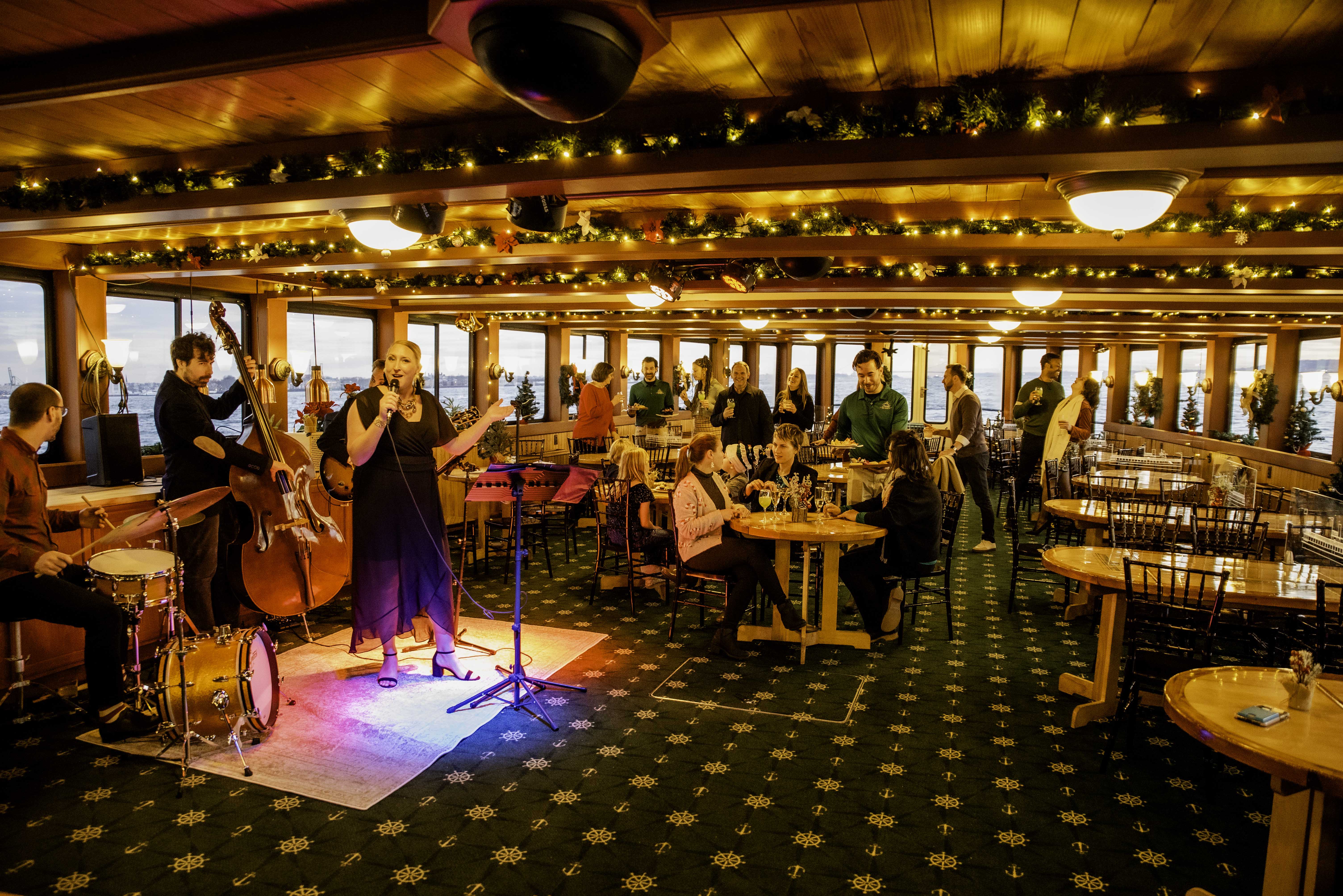 The interior salon of the Yacht Northern Lights decked out in Holiday decor as a band plays and guests enjoy food and drink