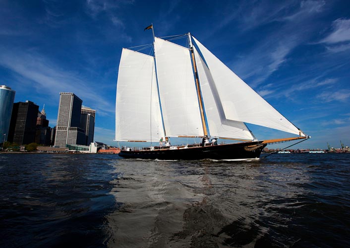 Full boat photo of Schooner America 2.0 with all four sails raised sailing in NY Harbor
