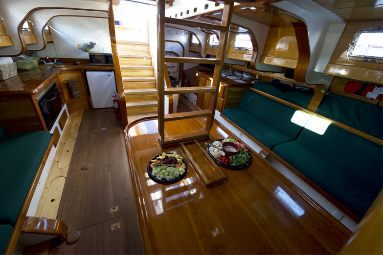 The interior salon of Schooner America 2.0 showcasing the table and cushioned seats