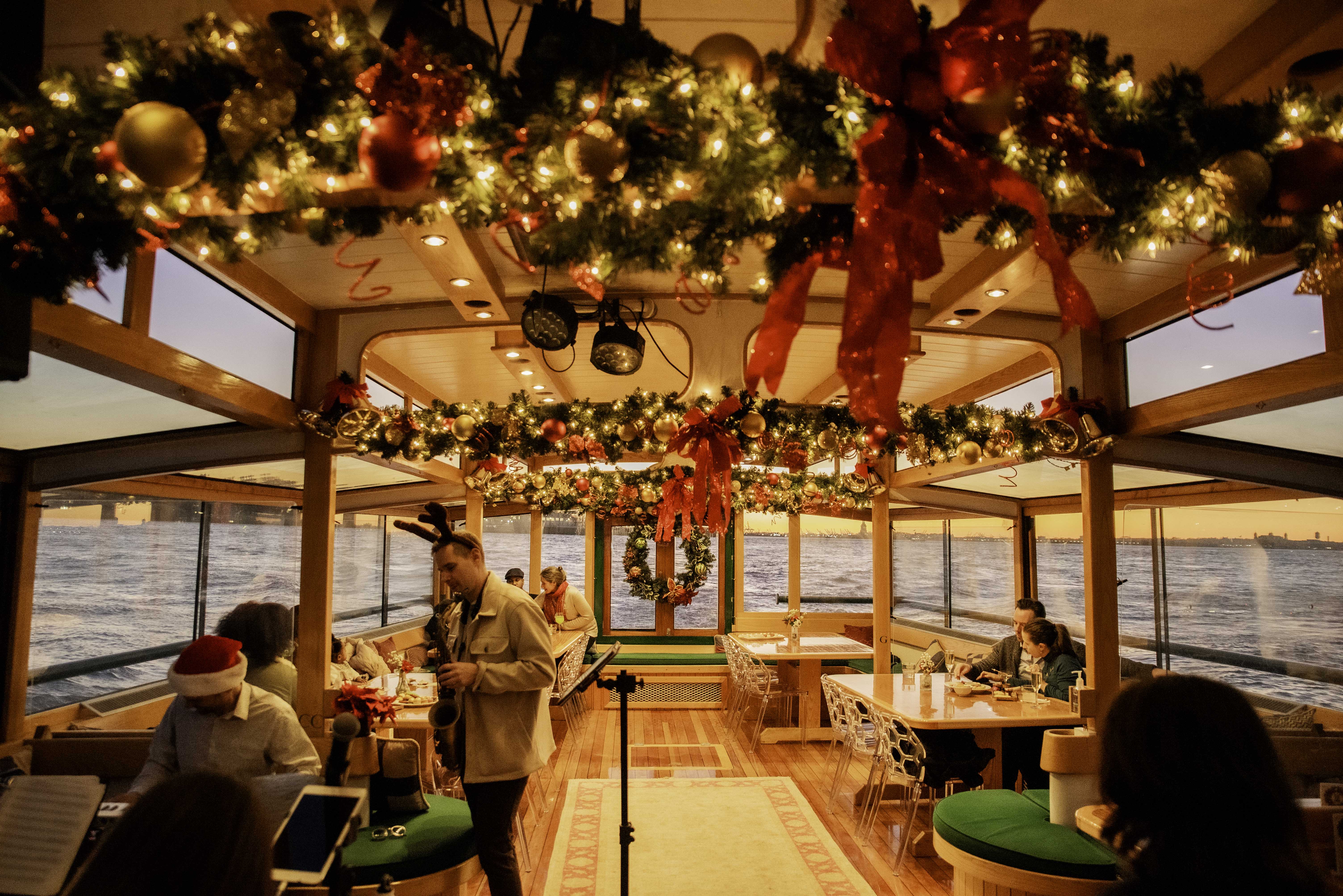 Gathering of people inside enjoying live holiday music at sunset aboard the yacht Manhattan II 