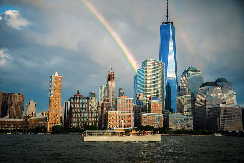 Full Boat Photo of Yacht Manhattan II in NY Harbor with the NYC Skyline in the background and a rainbow arching over the World Trade Center