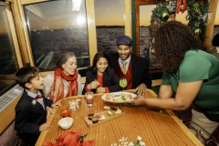 Family being served holiday cookies aboard a NYC Holiday cruise aboard they yacht Manhattan II
