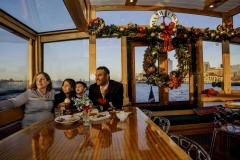 Family sitting at private table with holiday decor for a NYC sightseeing cruise