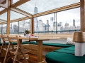 Private table inside yacht Manhattan II with the grand windows and NYC Skyline outside the windows