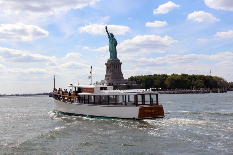 Full Boat Stern shot of yacht Manhattan cruising for a NYC Sightseeing cruise past the Statue of Liberty 